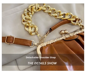 Detail of pleated brown leather bag with golden chain and detachable shoulder strap