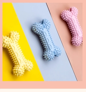 Gros plan de jouets à mâcher en forme d'os avec pointes en jaune, bleu et rose pour chiens