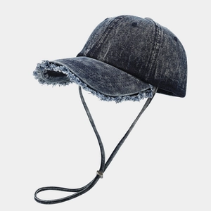 Dettaglio dei bordi sfrangiati e del cordino antivento sul berretto di jeans retro