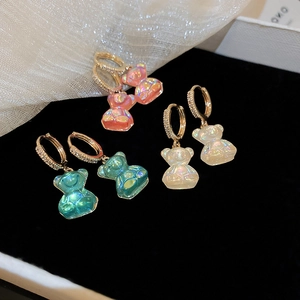 Détails de boucles d'oreilles oursons irisés avec des anneaux dorés sertis de zircons