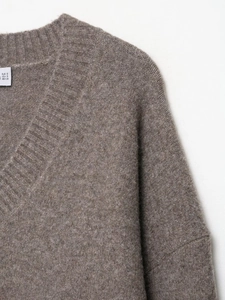 Detailed close-up of taupe V-neck knit sweater collar and soft texture
