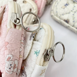 Close-up of quilted fabric organizer with cute rabbit pattern and metal ring zipper pull