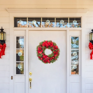 Close-up of festive Christmas wreath with red bows and berries on a white door
