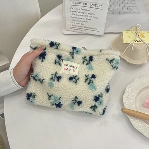 Close-up of plush floral cosmetic bag with soft texture and flower pattern embroidery