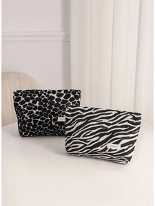 Beauty case minimalisti in peluche con stampa leopardata e zebrata su tavolo bianco