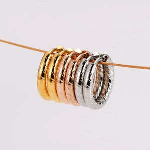 Three pairs of stainless steel hoop earrings in gold, rose gold and silver with spiral texture