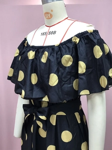Detail der gerafften Off-Shoulder-Linie und gelber Polka Dots auf schwarzem Kleid