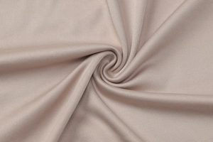 Gros plan sur un tissu en maille or champagne avec des plis spirales et une texture lisse