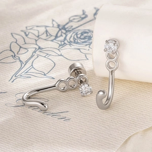 Polished cat tail titanium steel stud earrings with zircon crystals on blue floral background