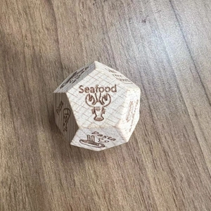 Macro view of wooden Date Night Dice showing engraved food options on wood surface