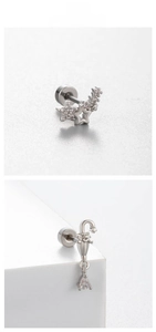 Detalle macro de piercings de plata con estrella y paraguas y cierre de rosca