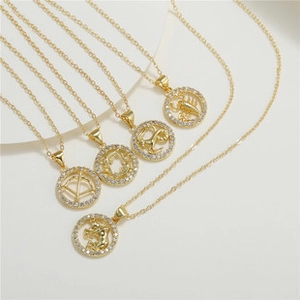 Detail of gold-plated zodiac necklaces with hollow round pendants and sparkling crystals