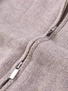 Macro detail of high-quality oatmeal knit fabric with a dual silver metal zipper closure