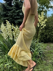 Detail des gelben Strick-Häkelmaxikleids mit schmaler Fishtail-Silhouette am Saum