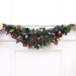 Christmas pine needle swag with red berries, pine cones and festive plaid bows