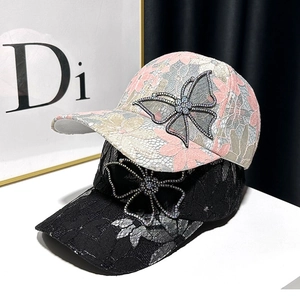 Close-up of sparkling rhinestone butterfly and floral lace on baseball cap