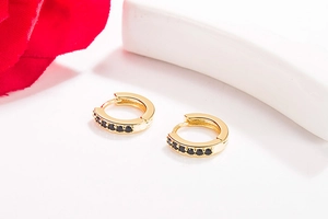 Close-up of 14K gold plated hoop earrings with micro-paved black crystals in a macro view