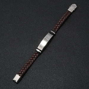 Close-up of brown braided leather bracelet with polished silver metal bar for men