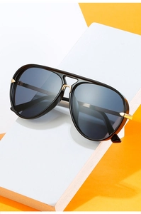 Detail der Pilotensonnenbrille mit schwarzem Rahmen, Gold-Scharnieren und dunklen Gläsern