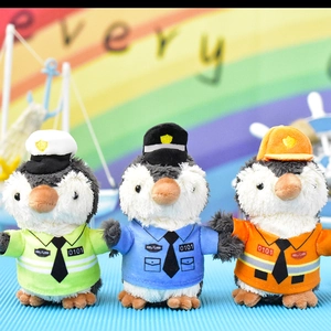 Nahaufnahme von drei süßen kleinen Pinguin-Plüsch-Anhängern in bunten Uniformen.