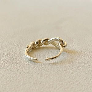 Macro detail of 925 sterling silver open ring with unique twisted knot design