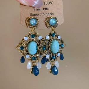 Macro shot of vintage resin earrings with turquoise stones and blue drop beads