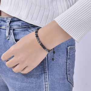 Close-up of Morse code beaded bracelet with matte black stones on a person's wrist