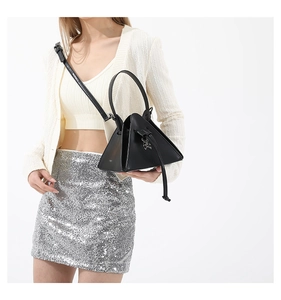Detail of dark punk triangle bag with silver skull clasp and detachable strap