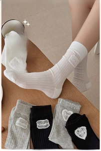 Close-up of ribbed texture and heart lace patch detail on stylish crew socks