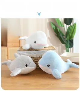 Detailansicht der Delphin- und Wal-Plüschtiere in Blau und Weiß auf einem Holztisch