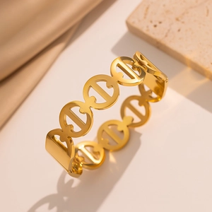 Bracciale a catena in acciaio inossidabile dorato su pietra materica e sfondo neutro