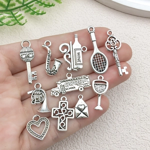Set of DIY antique silver alloy charms including cross and wine glass held in hand