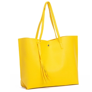Detail shot of the yellow lychee grain tote bag with tassel charm and magnetic closure