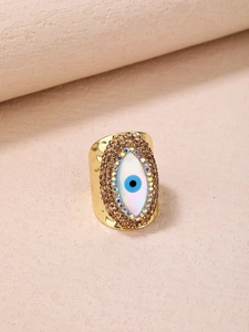 Macro detail of Evil Eye ring featuring colorful rhinestones and gold hammered texture