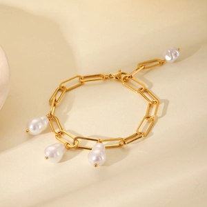 Close-up of 18K gold stainless steel chain bracelet with baroque pearl pendants