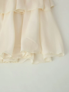 Dettaglio delle balze a strati e cuciture delicate sull'orlo della gonna in chiffon