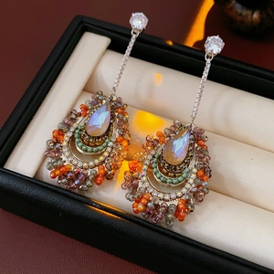 Detail of silver drop tassel earrings with opal stones on a black jewelry box display