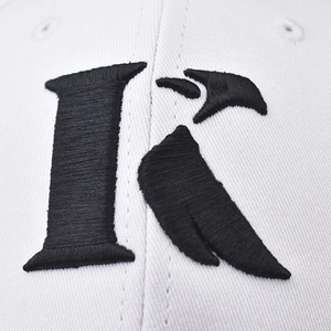 Detailed macro shot of premium black embroidered K letter on a white cotton baseball cap