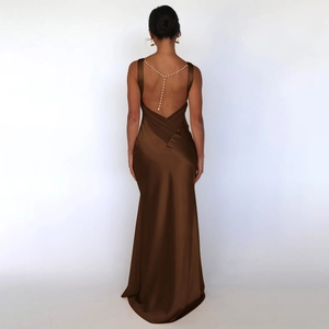 Close-up of brown satin backless dress featuring elegant pearl chain strap details