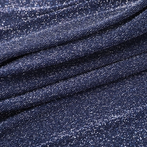 Macro shot of dark blue fabric with glittering silver metallic threads and soft texture