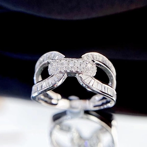 Elegant silver bow-shaped interlocking ring set with shimmering zircons on a dark surface