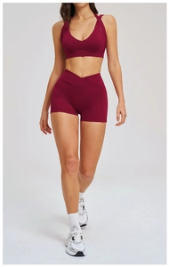 Dettaglio completo set yoga bordeaux con reggiseno a V e pantaloncini a vita incrociata con tasche