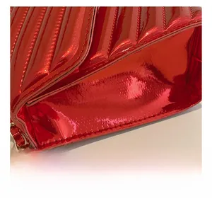 Detailed close-up of glossy red patent leather bag with premium quilted stitching craftsmanship