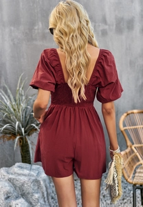 Detail view of the smocked back and puff sleeves on this wine red summer romper jumpsuit