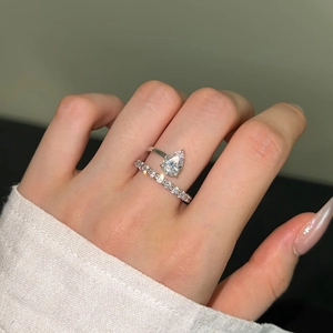 Macro shot of silver teardrop diamond ring set with pear-shaped stone and band