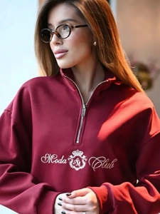 Detail of burgundy fleece hoodie featuring a half-zip collar and Moda Club embroidery