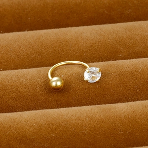 Macro view of gold U-shaped ear piercing with clear zircon on brown velvet display