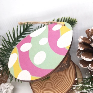 Macro shot of egg-shaped wooden Easter ornaments with colorful wave patterns and twine