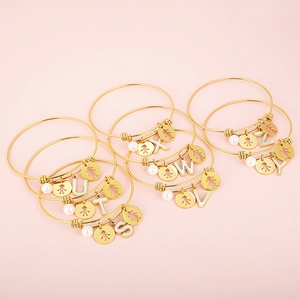 Adjustable gold titanium steel bracelet with pearls and hollow alphabet letter charms