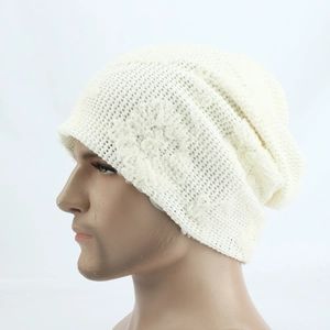 Detail of breathable hollow knit pattern and floral decoration on a cream slouchy beanie